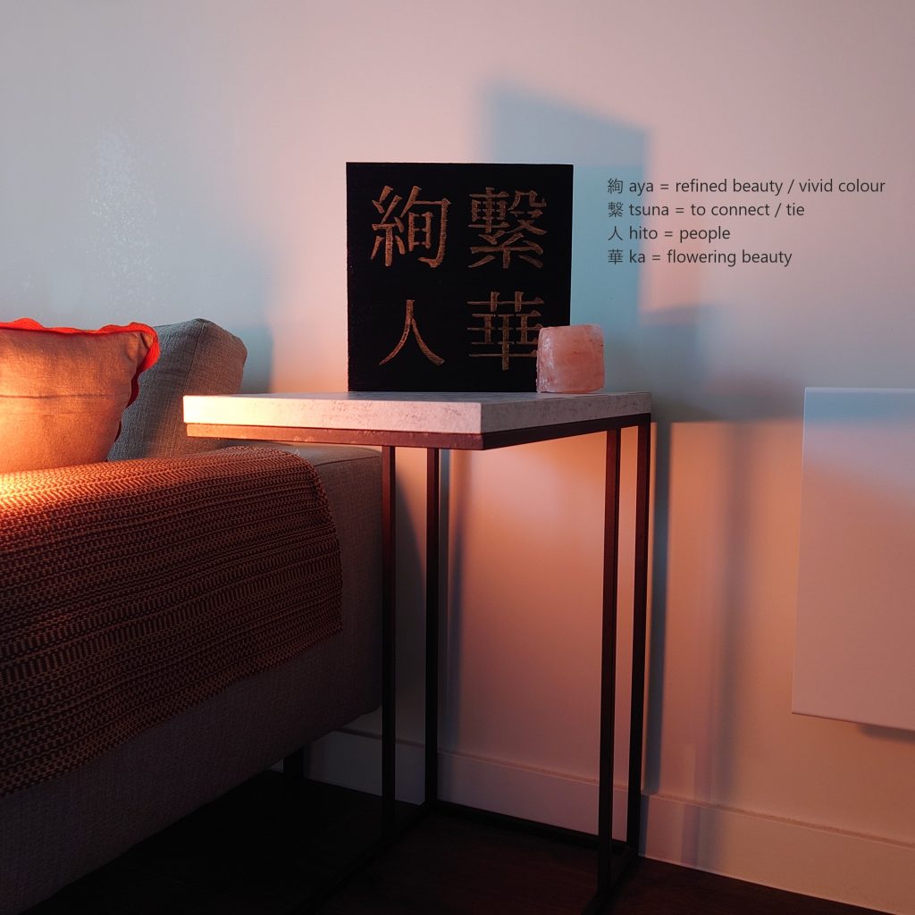 black and gold acrylic Japanese kanji painting in Scandinavian living room on a table