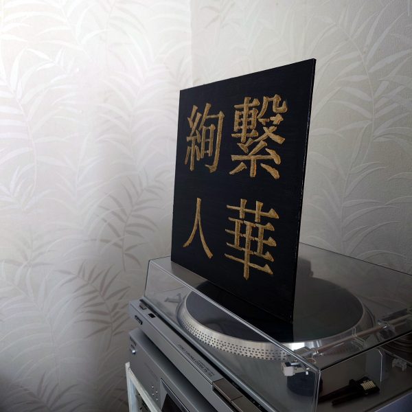 black and gold acrylic Japanese kanji painting on record player - side view